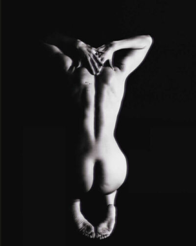 Artistic black and white photograph of a nude figure with a focus on the back and legs.