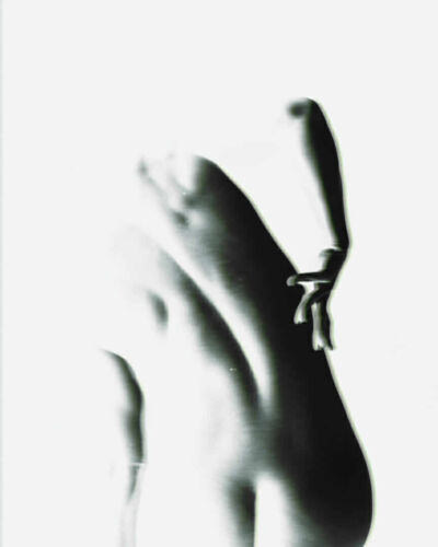 Artistic black and white depiction of a nude human figure with a focus on the torso and arm.