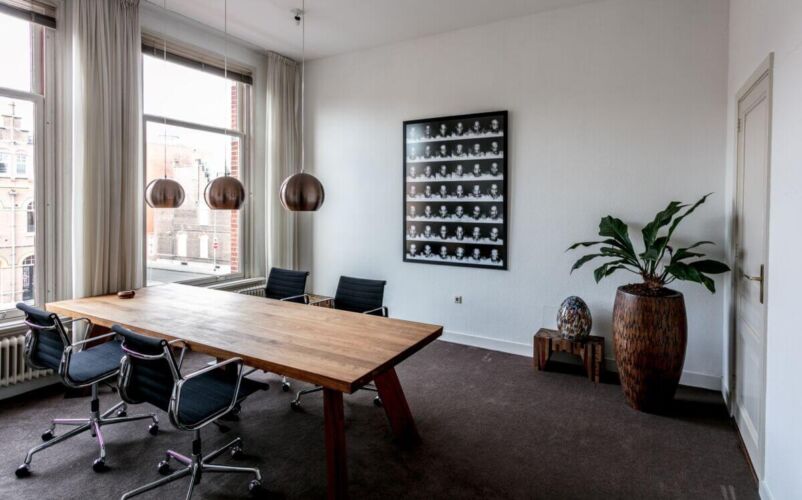 Conference room featuring a wooden table, black chairs, and decorative wall art.