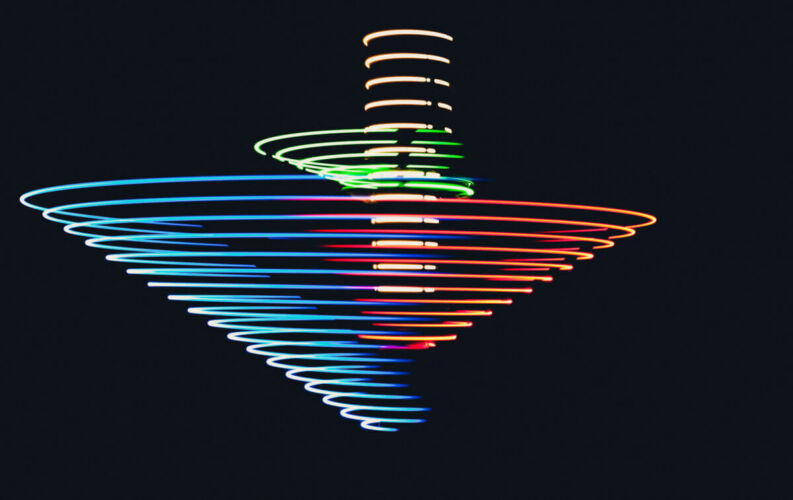 A colorful spinning top creating light trails in a dark background.