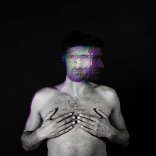 Black and white portrait of a man with distorted facial features and a blurred effect.