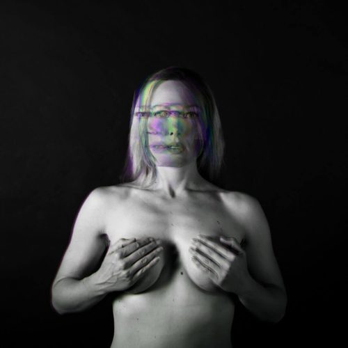 Black and white portrait of a woman with a distorted face and hands covering her chest.