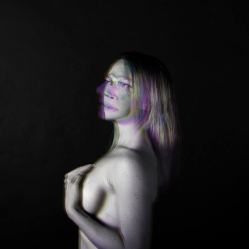 Artistic portrait of a woman with abstract visual effects and a dark background.