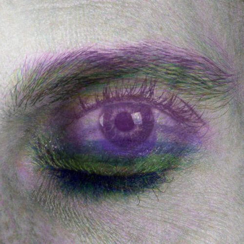 Close-up image of a human eye featuring artistic purple and green color effects.
