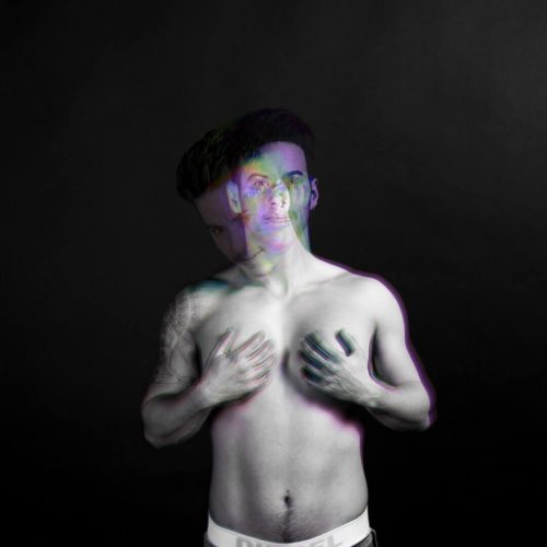 A black and white portrait of a man with a double exposure effect showing two overlapping images.