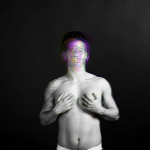 Black and white portrait of a man with an abstract multi-colored effect on his face and upper body.