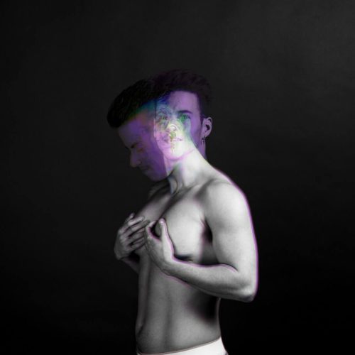 Black and white portrait of a male figure with a blurred effect on the face and body.