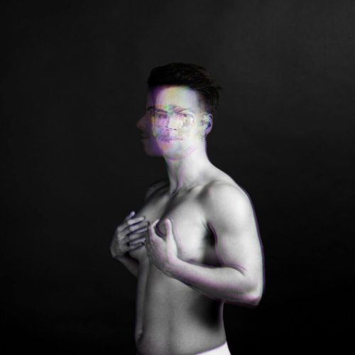 Black and white portrait of a male figure with a double exposure effect, showing a blurred face and torso.