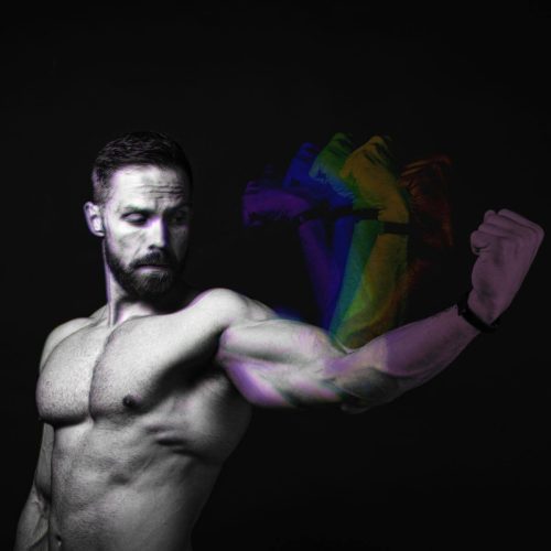 Muscular man flexing his arm with a colorful motion blur effect on his fist.