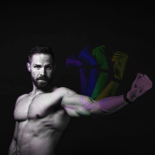 A muscular man flexing his arm with colorful fist silhouettes in the background.