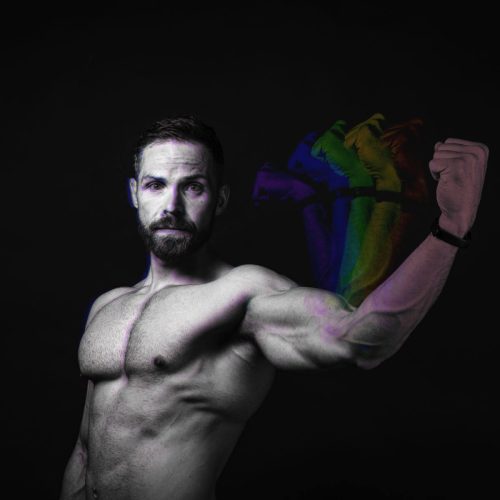 A muscular man flexing his arm with colorful fists appearing in motion behind him.
